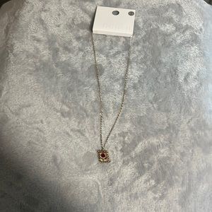 Gold necklace with red rose charm